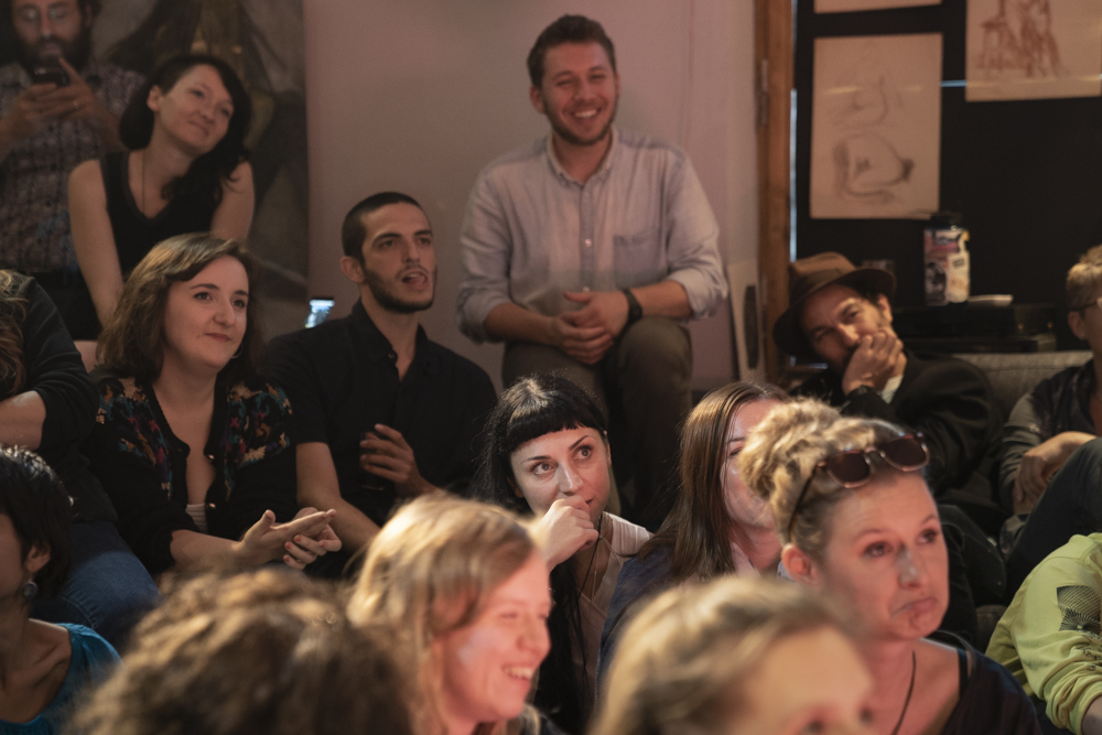 Audience watch a performance in Deitla 29, the central apartment/hub for FestivALT